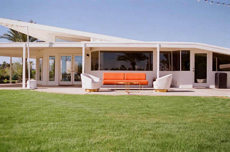 A mid-century modern house and lawn with outdoor seating